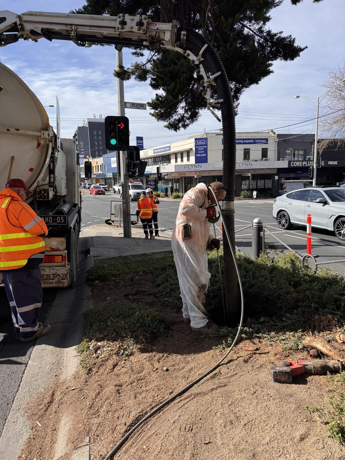 The hydrovac excavation unit set up on the Nepean Highway median, with a large tree and live traffic alongside.